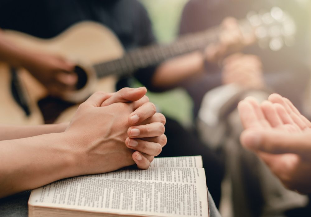 Christian prayer group with bible by playing the guitar to worship God